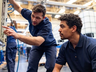 Two men fixing a machine